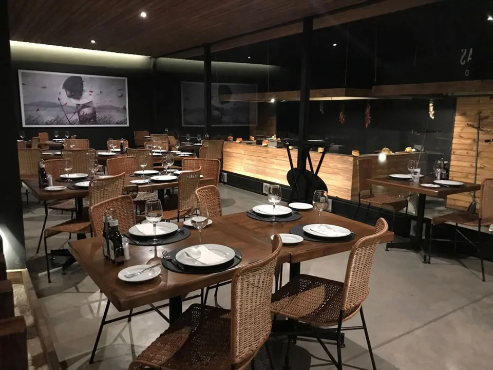 El salón de la casona, con mesas de madera y ratán